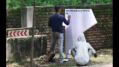 Workers sprucing up direction signboards with a fresh coat of paint ahead of the NAAC visit at Panjab University in Chandigarh on Tuesday. (Ravi Kumar/HT) Workers sprucing up direction signboards with a fresh coat of paint ahead of the NAAC visit at Panjab University in Chandigarh on Tuesday. (Ravi Kumar/HT)