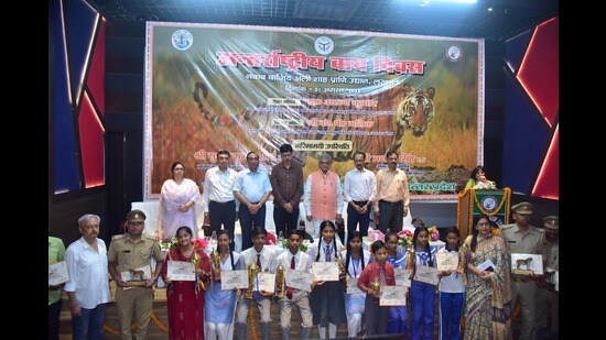 The student prize winners and officials who were felicitated at the Lucknow zoo celebration of Global Tiger Day, with zoo director Aditi Sharma, and forest minister Arun Kumar Saxena (HT Photo)