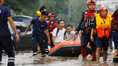 Rescue workers evacuate flood-affected residents using a boat after remnants of Typhoon Doksuri brought rains and floods in Beijing. (REUTERS)