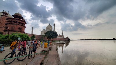 Locals at Dussehra Ghat behind the Taj Mahal after the floodwater of the Yamuna river receded, in Agra, on Wednesday. (PTI)