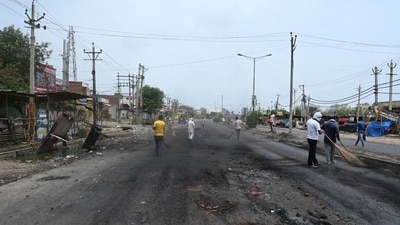 Workers remove debris and stone from a street in Gurugram. Workers remove debris and stone from a street in Gurugram.
