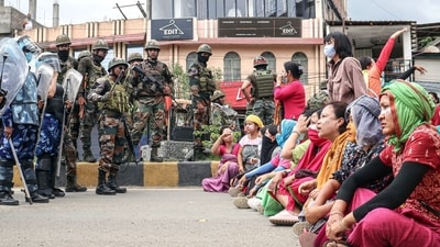 Paramilitary personnel stand guard as people stage a protest against the mass burial of Kuki-Zomi people killed in Manipur's ethnic violence, in Imphal on Thursday. (ANI Photo) Paramilitary personnel stand guard as people stage a protest against the mass burial of Kuki-Zomi people killed in Manipur's ethnic violence, in Imphal on Thursday. (ANI Photo)