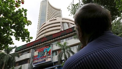 A man looks at a screen across a road displaying the Sensex on the facade of the Bombay Stock Exchange (BSE) building in Mumbai. (REUTERS)