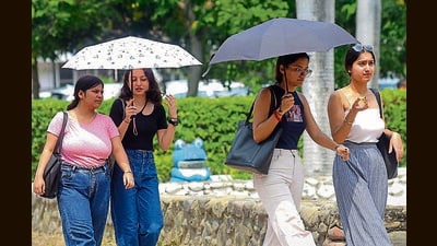 Students taking cover under umbrellas at Panjab University, Chandigarh, on a scorching Thursday. (Keshav Singh/HT)