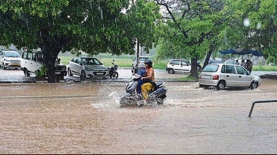 A woman and a child caught in the heavy rain in Sector 40, Chandigarh. (Ravi Kumar/HT)