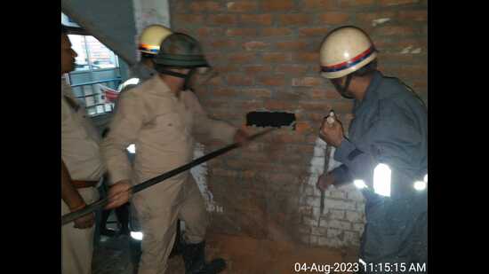 Firefighters working to rescue the worker who fell in an under-construction lift duct (HT Photo)