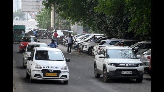 The six-lane road contracts to a single lane on one side due to vehicles parked outside the Advant building. (Sunil Ghosh/HT Photo)