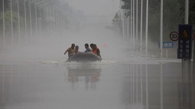 People ride a boat through a flooded road after the rains and floods brought by remnants of Typhoon Doksuri, in Zhuozhou, Hebei province, China August 3, 2023. (REUTERS)