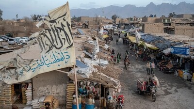 People walk through a market with old Taliban flags flown above in a town in a remote region of Afghanistan. (AP)