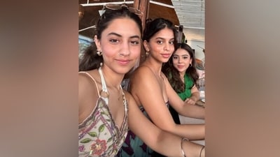 Suhana's post featured a selfie with her cousin, Alia Chhiba, and their friend. It shows the trio sitting at a restaurant. Suhana wore a printed spaghetti-strap dress for the outing. She styled it with a messy bun, no-makeup look, glowing skin, and glossy nude lips. (Instagram) Suhana's post featured a selfie with her cousin, Alia Chhiba, and their friend. It shows the trio sitting at a restaurant. Suhana wore a printed spaghetti-strap dress for the outing. She styled it with a messy bun, no-makeup look, glowing skin, and glossy nude lips. (Instagram)