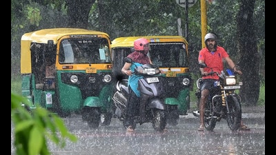 Commuters caught in the rain at the Sector 34-35 dividing road in Chandigarh on Sunday. (Keshav Singh/HT)