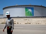 An Aramco employee walks near an oil tank at Saudi Aramco's Ras Tanura oil refinery and oil terminal in Saudi Arabia.