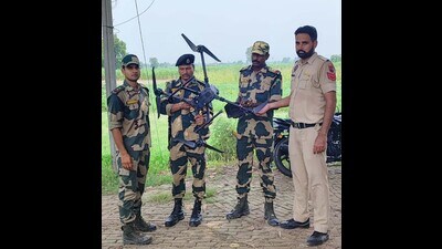 BSF personnel and Punjab Police personnel with a drone recovered in Tarn Taran on Monday. (HT photo)