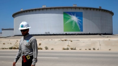 An Aramco employee walks near an oil tank at Saudi Aramco's Ras Tanura oil refinery and oil terminal in Saudi Arabia. (REUTERS)