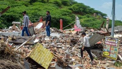 Shopkeepers look at the debris of their shops demolished by the administration in Nuh on Monday. (PTI) Shopkeepers look at the debris of their shops demolished by the administration in Nuh on Monday. (PTI)