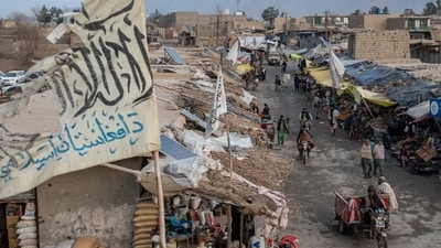 People walk through a market with old Taliban flags flown above in a town in a remote region of Afghanistan. (AP) People walk through a market with old Taliban flags flown above in a town in a remote region of Afghanistan. (AP)