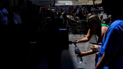 Australian tourist fills her bottle of water at a fountain.