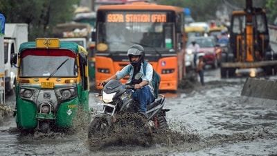 Commuters wade through a waterlogged road after rainfall, in New Delhi on Friday. (ANI Photo) Commuters wade through a waterlogged road after rainfall, in New Delhi on Friday. (ANI Photo)