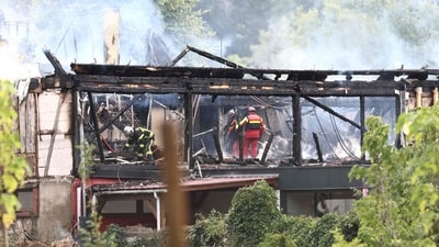 TOPSHOT - Firefighters inspect a burnt building after a fire erupted at a holiday home for disabled people in Wintzenheim, eastern France, on August 9, 2023. Eleven people were missing following a fire at a centre, where a group of adults with learning disabilities were taking their holidays, authorities said. Seventeen people were safely evacuated, with one person hospitalised and another treated for shock. (Photo by Sebastien BOZON / AFP) (AFP)