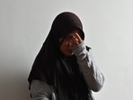 Siti Khotimah wiping away her tears as she speaks about the physical abuse she suffered by her employer while working as a domestic worker, during an interview at a shelter in Jakarta. (AFP)