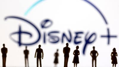 FILE PHOTO: Toy figures of people are seen in front of the displayed Disney + logo, (REUTERS)