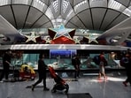 Travellers walk past an installation in the shape of five stars, at Beijing Daxing International Airport in Beijing, China. China allows group tours to US, UK, Australia, South Korea, Japan in test for travel demand 