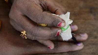 An election official puts indelible ink on the finger of a voter. (AFP File Photo)