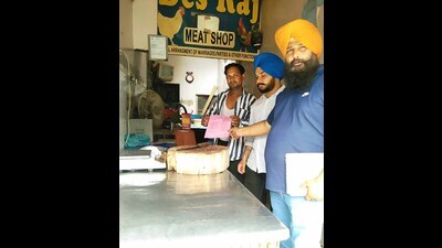 MC officials issuing challan to a meat shop owner on Gill road in Ludhiana on Friday.