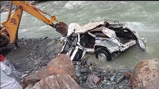 The mangled remains of the SUV being fished out of the rivulet in Chamba’s Churah on Friday morning. (HT Photo)