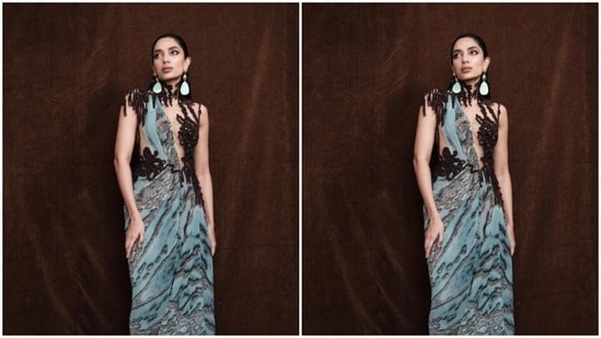 Sobhita decked up in a pastel blue silk gown featuring prints in shades of grey and black. The asymmetrical gown featured transparent netted details at the torso and a black netted bodice in a dramatic halter neckline.&nbsp;(Instagram/@sobhitad)