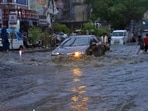 Cars drive through a flooded road caused by heavy monsoon rainfall. Cars drive through a flooded road caused by heavy monsoon rainfall.
