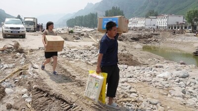 Villagers carrying disaster relief supplies walk back to their home in Shangzhuang village of Sanpo Town, Laishui county in northern China's Hebei Province. (AP)