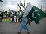 A man carrying Pakistan's national flags, walks through a street on the eve of country's Independence Day celebrations in Peshawar on August 13.