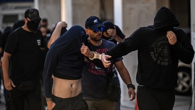 Football fans, most of them from Croatia, cover their faces while leaving the Athens Police Headquarters in Athens (AFP) Football fans, most of them from Croatia, cover their faces while leaving the Athens Police Headquarters in Athens (AFP)