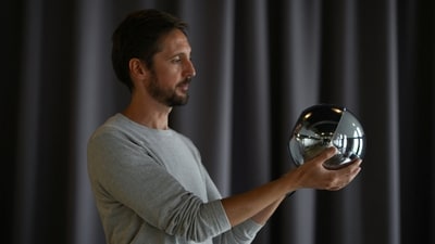 Ricardo Macieira, regional manager, Europe holds the biometric imaging device, the Orb of the identity and financial public utility Worldcoin in his hands, to create a World ID digital passport, being able to trade in cryptocurrency issued, in Berlin, Germany. (REUTERS)