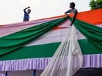Laborers decorates a stage with colors of the Indian flag at a venue of Independence Day celebrations.