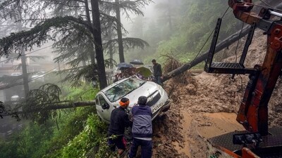 People pull a vehicle to a safer place after a landslide following heavy rainfall, in Shimla, Sunday. (PTI) People pull a vehicle to a safer place after a landslide following heavy rainfall, in Shimla, Sunday. (PTI)