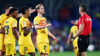 Barcelona's Frenkie de Jong, centre, and Barcelona's Raphinha, centre left, talk to referee Guillermo Cuadra Fernandez during the Spanish La Liga soccer match between Getafe and FC Barcelona (AP) Barcelona's Frenkie de Jong, centre, and Barcelona's Raphinha, centre left, talk to referee Guillermo Cuadra Fernandez during the Spanish La Liga soccer match between Getafe and FC Barcelona (AP)