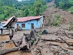 A security personnel carries the belongings of a villager from the site of a landslide after heavy rains at Jadon village in Solan district. A security personnel carries the belongings of a villager from the site of a landslide after heavy rains at Jadon village in Solan district.