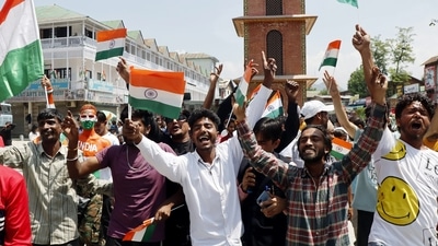People holding the national flags take part in the 77th Independence Day celebrations