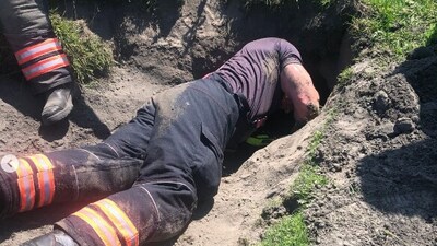 Firefighter going down the rabbit hole to save a dog. (Facebook) Firefighter going down the rabbit hole to save a dog. (Facebook)