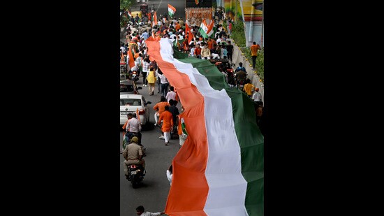Residents march with a huge Tricolour from Noida Stadium to Sector 30 on the occasion of Independence Day. (Sunil Ghosh/HT Photo)