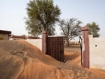 A house's entrance gate is buried under the sand at the Bedouin village of al-Ghuraifa, about 100 km, 62 miles, southeast of Sharjah, United Arab Emirates. Built-in the 1970s, the village was abandoned two decades later as oil wealth transformed the country into a global hub of commerce and tourism, home to the futuristic cities of Dubai and Abu Dhabi. 