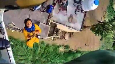A video grab of a woman being rescued by the Indian Air Force during an operation to evacuate stranded residents in flood-hit Kangra district on Wednesday. (PTI Photo) A video grab of a woman being rescued by the Indian Air Force during an operation to evacuate stranded residents in flood-hit Kangra district on Wednesday. (PTI Photo)