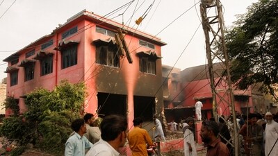 People gather at a church building vandalized by protesters in Jaranwala, Pakistan. (REUTERS)