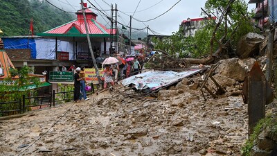 Commuters walk by the debris that has blocked the Chandigarh-Manali highway after a landslide, near Mandi. (PTI Photo) Commuters walk by the debris that has blocked the Chandigarh-Manali highway after a landslide, near Mandi. (PTI Photo)