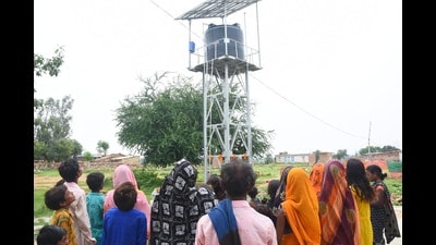 Villagers admiring the water tank, a part of MUNPL’s solar-powered mini water scheme at Salaiya Khurd village of Prayagraj (HT PHoto)