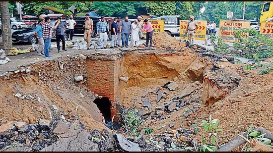The a 15-ft deep and 20-ft wide crater in the middle of the road neat Krishna Temple in Model Town Extension area in Ludhiana. (HT PHOTO)