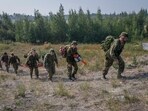 Canadian Armed Forces soldiers head to the forest to construct a firebreak behind Parker Recreation Field in Yellowknife to help fight wildfires