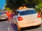 Man performing stunt on roof of moving car in Noida